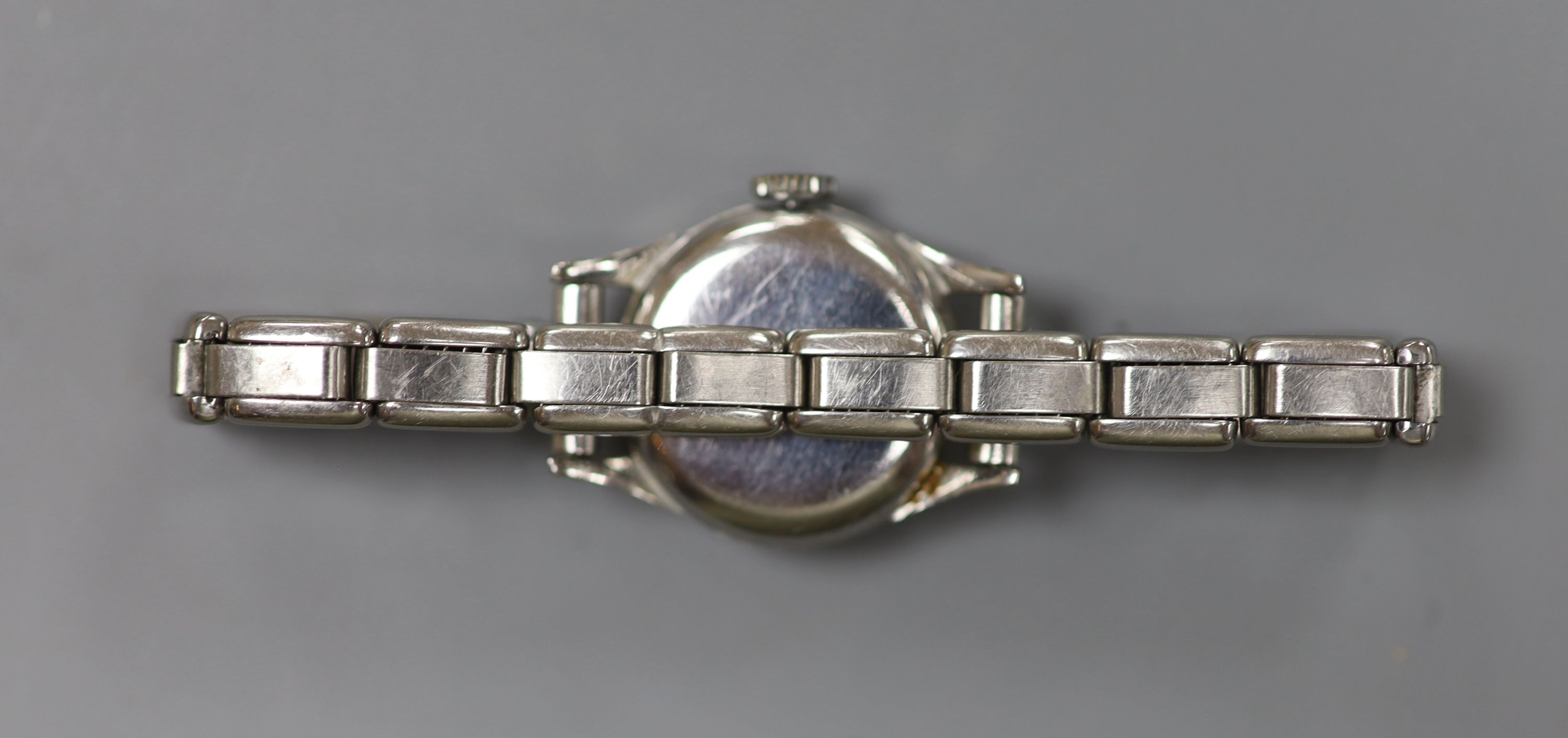 A lady's stainless steel Omega manual wind wrist watch, on associated flexible bracelet.